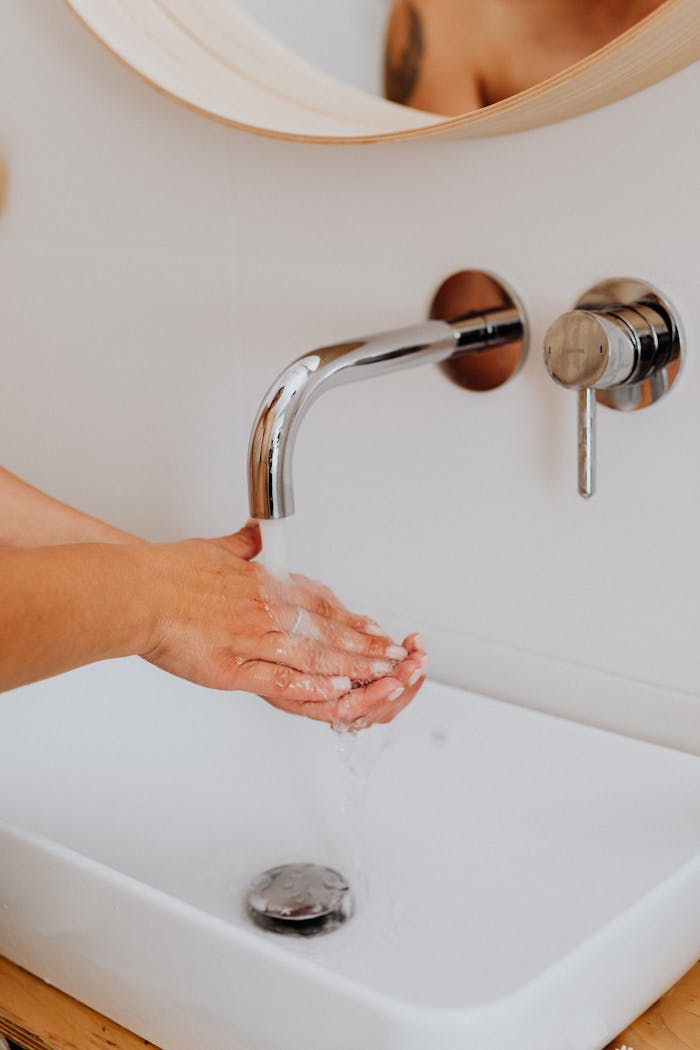 person cleaning hands on lavatory 5240607